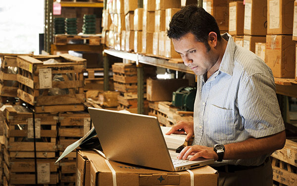 Man using a laptop in a warehouse