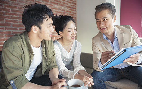 A man explaining documents to a couple